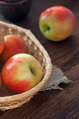 Fresh apples in a basket on the wooden table