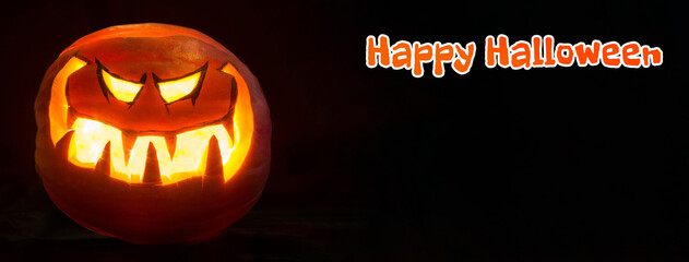 Happy Halloween lettering wide mockup copy space. Pumpkin smile and scrary eyes for party night. Black background.