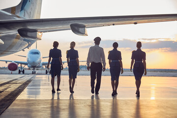 Back view image of unrecognizable people going to the aircraft in the outdoors