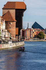 Obraz premium The largest medieval port Crane in Europe and historic buildings on the Dlugie Pobrzeze over the Motlawa River in Gdansk, Poland.