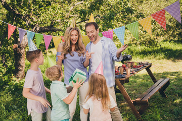 Portrait of nice attractive cheerful cheery gad full big family small little brother sister fatherhood motherhood friends friendship congratulating occasion giving giftboxes picnic © deagreez