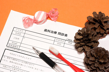 歯科問診票と歯ブラシ、飴・松ぼっくり・ハロウィン