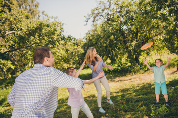Fototapeta premium Portrait of nice attractive adorable cheerful cheery full big family brother sister throwing frisbee having fun enjoying fresh air active hobby sunny day daydream in green park summertime