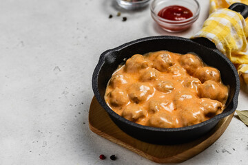 Swedish meatballs in creamy sauce in cast iron skillet. space for text.