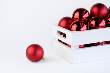 Red christmas balls inside a white wooden box with copy space