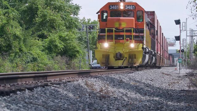 Low angle view of a freight train passing by in slow motion.