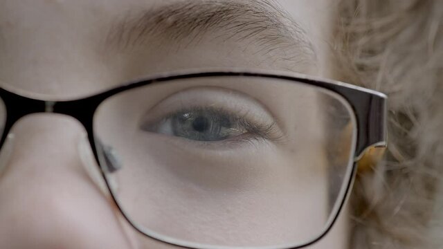 Closeup on a young boy's pretty blue eye looking into camera.