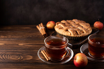 Obraz na płótnie Canvas apple pie with cinnamon and hot black tea in glass cup