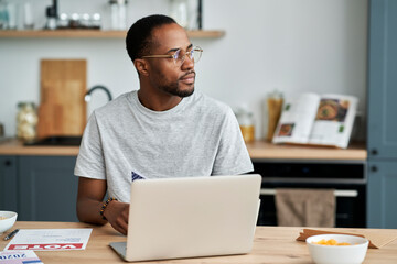 Thoughtful black man voting by mail from home