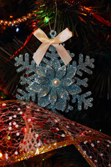 Christmas decoration "snowflake" hanging on a branch of a fir tree. Christmas background with a Christmas tree toy.