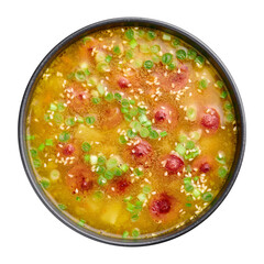 Dry Pea Soup with meat sausages, potato, green onions and sesame. Yellow Pea Soup in black bowl isolated on white background. Top view