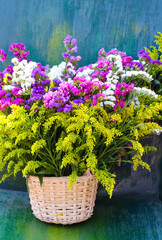 Colorful flower in bamboo wood basket  on table background