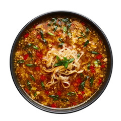 Veg Manchow Soup in black bowl isolated on white background. Vegetarian Manchow Soup is indo-chinese cuisine dish with bell peppers, cabbage, carrot, noodles, chilli, soy sauce and green onion.