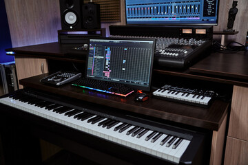Fototapeta na wymiar Recording studio equipment. Midi synthesizer with screen keyboard and loudspeaker for creating music