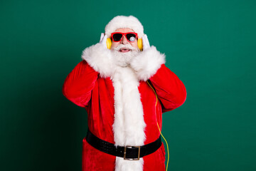 Portrait of his he nice attractive handsome glad cheerful cheery Santa father listening different music soul jazz having fun enjoying isolated over green color background