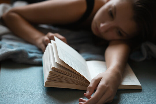 Girl studiing for her exams from a book.