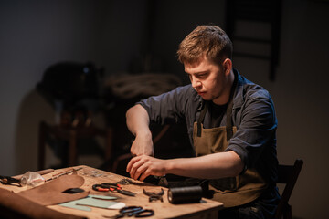 a hereditary shoemaker makes shoes from leather in the family workshop