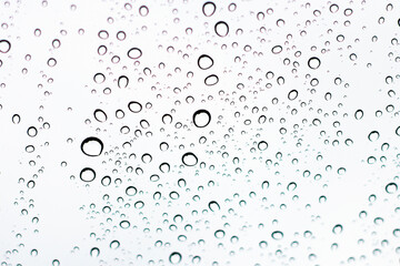 Water droplets adhering to the windshield of the car.