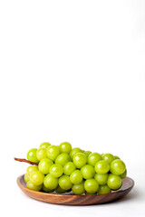 Green grapes on a wooden plate