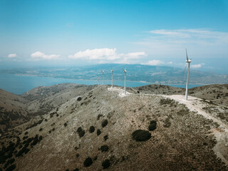 Lots of wind turbines in a mountain region of Kefalonia island in Greece with sea in the distance