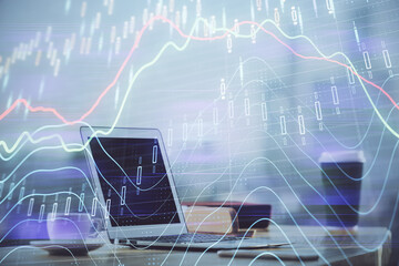 Stock market graph on background with desk and personal computer. Double exposure. Concept of financial analysis.