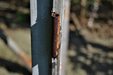 Rusted metal in old wooden part. Rusty hinge iron on wooden door with blurred background in vintage house.