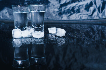 Vodka. Shots, glasses with vodka with ice .Dark background. Copy space .Selective focus