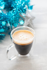 one glass cup of coffee with Christmas decoration on ceramic background