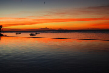 panoramic red sunset over the sea on tropical island with beautiful sky reflection in the water