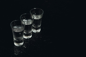 Vodka. Shots, glasses with vodka with ice .Dark background. Copy space .Selective focus