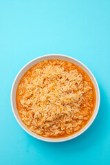 tomato rice in bowl on blue background