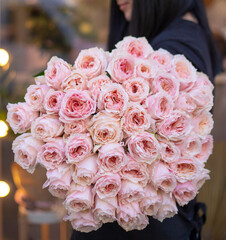 Fresh beautiful flower. Woman holding a big passion flower bouquet of roses 