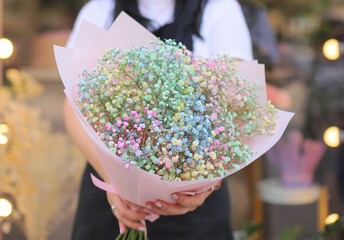Fresh beautiful flower. Woman holding a big delicate flower bouquet of gypsophila wrapped in paper.