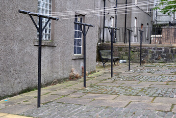 Deserted Stone Courtyard of Old Residential Building with Metal Laundry Posts & Bench 