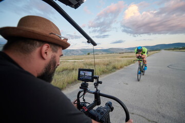 videographer taking action shot of triathlon athlete while riding bike