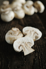 Fresh champignon mushrooms on wooden table, closeup. Space for text