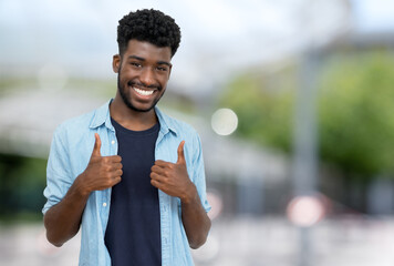 Cheering young adult man from Africa with beard and casual clothes