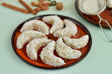 Vanillekipferl, German classic Christmas crescent cookies with powdered sugar. Decorated with poinsettia flower. 