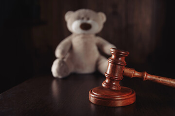 Divorce and separation concept. Wooden gavel and teddy bear as a symbol children's protection.