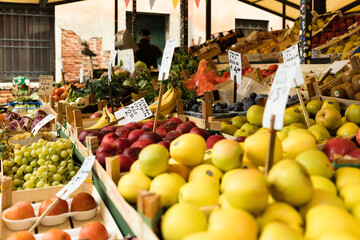 fruits and vegetables at the italian market in Venezia (Venice), Italy; close up of apples, kaki, grape