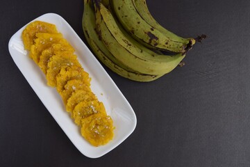 Fried Green Plantains or Tostones on black background