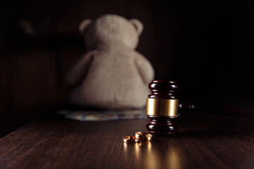 Alimony payment. Dollar banknotes, wooden judge gavel with rings and teddy bear. Family divorce and...