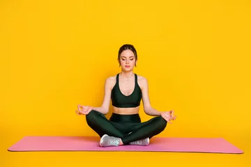  Portrait of attractive thin sportive calm tranquil girl doing yoga class meditation isolated on bright yellow color background © deagreez