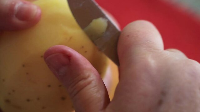 M&atilde;os descascando batatas