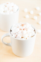 Cup of hot cocoa with marshmallows on wooden background