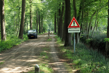 Warning sign for a ford in a rural forest road near Winterswijk, Netherlands