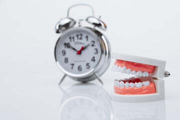 Jaw model and alarm clock. Teeth treatment concept.