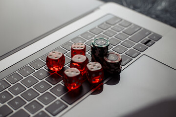 Online casino theme. Gambling chips and red dices on keyboard.