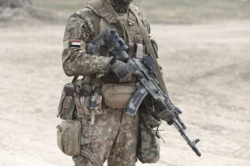 Soldier with machine gun and flag of Sudan on military uniform. Collage.