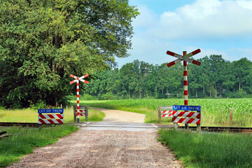 Unpaved road with unguarded railroad crossing in a forested area near Winterswijk, Netherlands